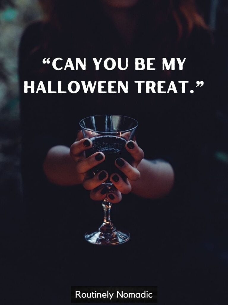 Hands holding dark drink with Halloween sayings